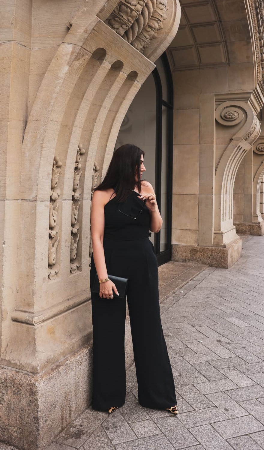 Hatice Tekin standing beside a monumental stone arch